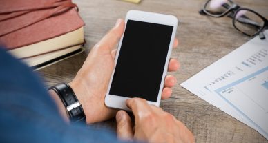 foto de homem mexendo no iphone com a tele preta